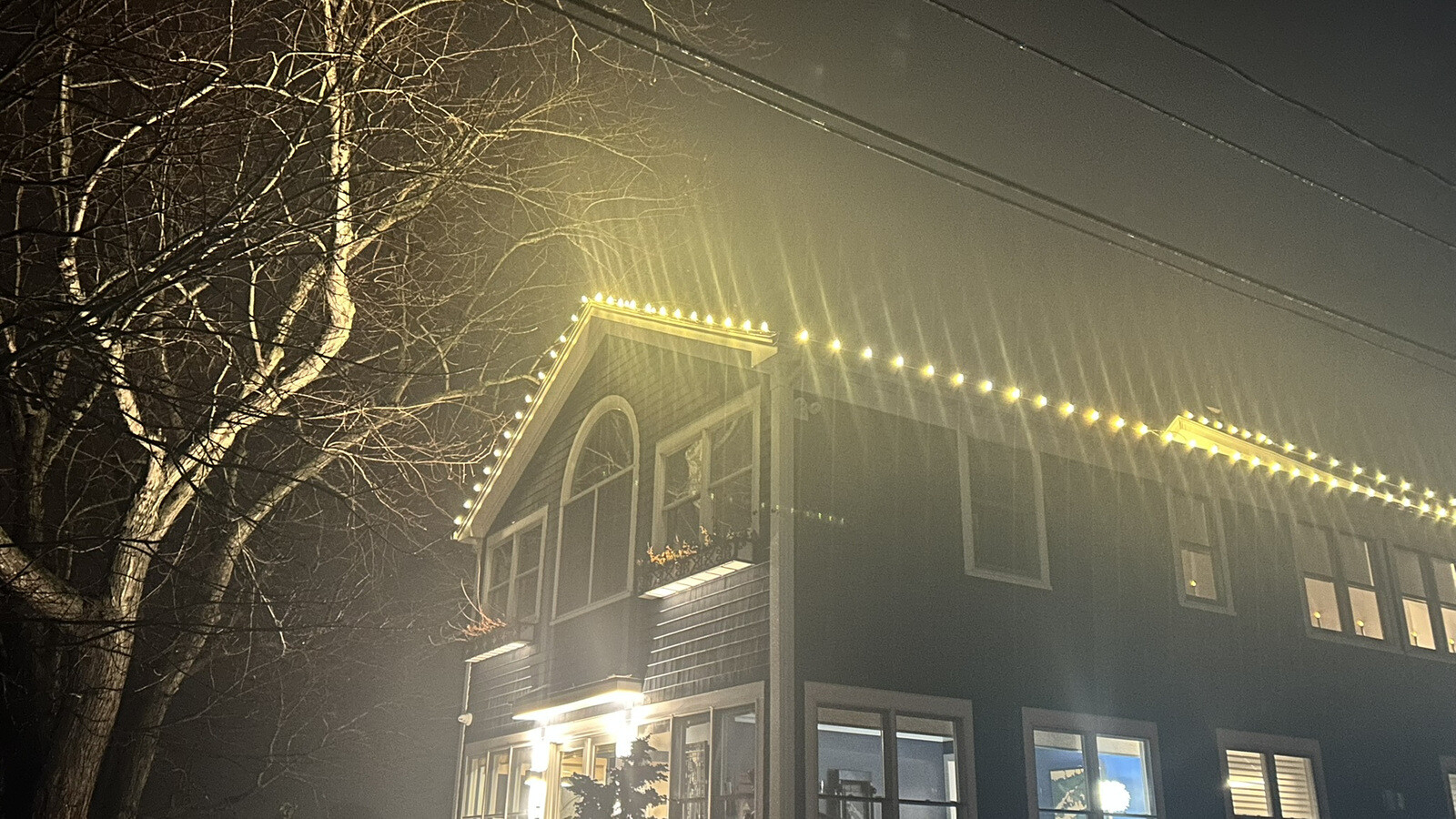 Permanent LED roofline lighting on an upscale home at dusk